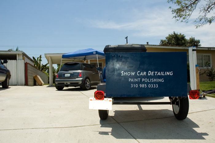 The ShowCarDetailing trailer — 'Paint Polishing, 310-985-0333.' The original name, before California tried to fine Richard $10,000 for it.