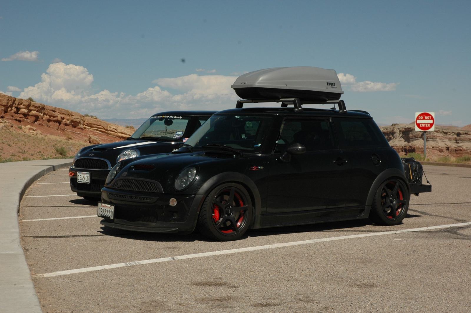 Red rock country. The OBSSSSD MINI on a road trip — Thule box on the roof, red calipers peeking through the wheels.