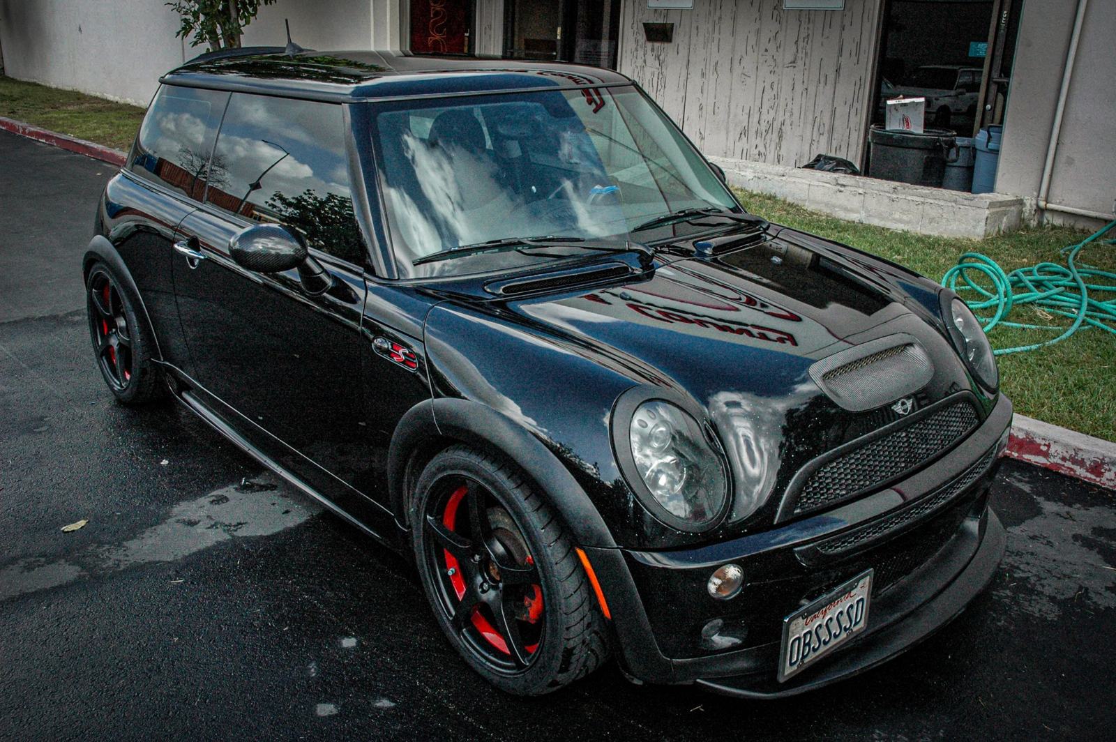 The OBSSSSD MINI parked outside the first shop — black on black, red calipers, fresh off a detail. The obsession was already in the name.